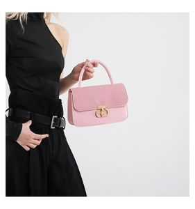Detail showing pink textured fabric and smooth leather contrast on the small square bag