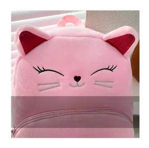 Close-up of pink plush cat backpack featuring glittery red ears and embroidered face