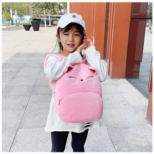 Pink plush cat backpack for kids with embroidered face details and 3D ears on a child's back