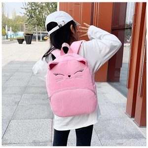 Rear view of a child wearing a pink plush cat backpack on a city street