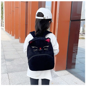 Close-up of black plush cat-shaped backpack for kids featuring 3D ears and embroidery