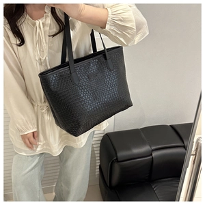 Close-up of the woven texture and brand logo detail on this large black tote bag