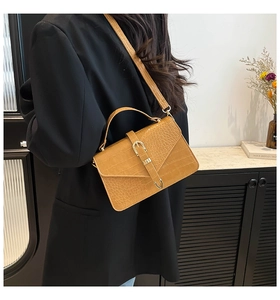 Détail du sac jaune à motif crocodile avec boucle dorée et bandoulière réglable