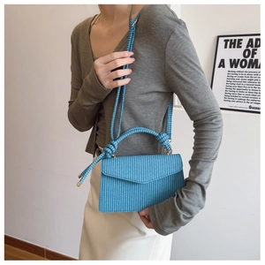 Détail du tissage bleu vif sur le sac à main avec poignée nouée et bandoulière
