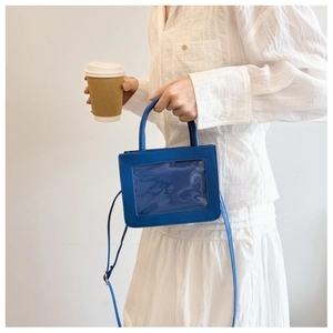 Sac bandoulière bleu avec fenêtre transparente et sangle réglable porté par le mannequin