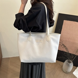 White woven texture tote bag with shoulder straps shown in a minimalist office setting