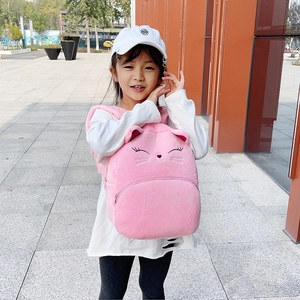 Pink plush cat backpack for kids with 3D ears and cute embroidery on a sunny day