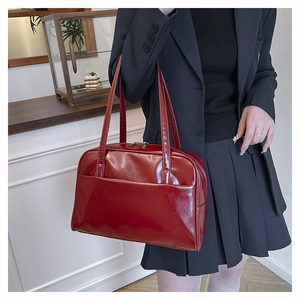 Detail of dark red vintage faux leather Boston bag with glossy finish and shoulder straps