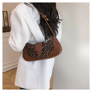 Détail d'un sac sous le bras léopard vintage avec boucle éclair sur un blazer blanc