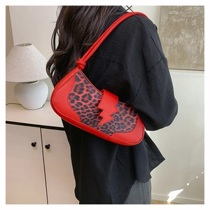 Détail du sac léopard rouge avec boucle éclair et bandoulière à nœuds