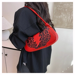 Détail du sac baguette en cuir rouge avec imprimé léopard et patch éclair décoratif