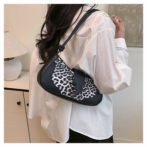 Détail du sac léopard avec décor éclair, porté sur une chemise blanche pour un look chic