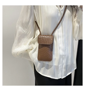 Detailed view of the brown woven texture and flap design on this elegant crossbody phone bag