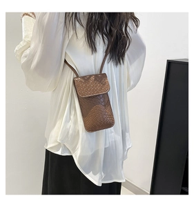 Detail showing the brown woven texture and PU leather craftsmanship of the crossbody bag