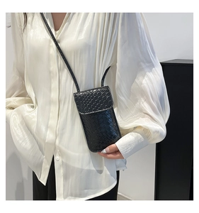 Close-up of black woven texture on a mini rectangular crossbody phone bag for women