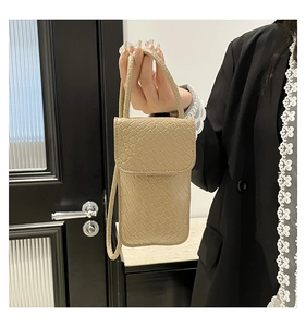 Detail of mini crossbody phone bag with crocodile embossed texture in beige faux leather