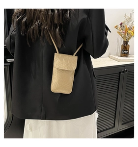 Beige woven leather phone bag worn by model showing practical size and long strap