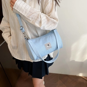 Light blue cylinder canvas crossbody bag featuring a cute cartoon dog patch and strap