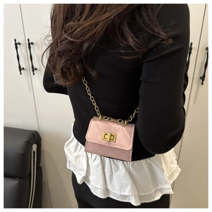 Close-up of pink mini crossbody bag with litchi texture and golden chain strap