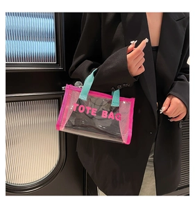 Close-up of transparent mesh tote bag with pink trim and mint green handles