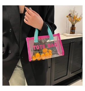 Detail of transparent PVC tote bag with mesh trim and vibrant pink handle accents