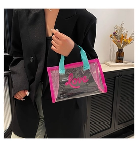 Close-up of clear PVC tote bag with pink mesh trim and love print on front