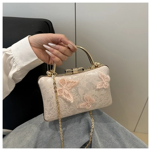 Detail of lace clutch with 3D butterfly floral appliques and a crystal bow clasp