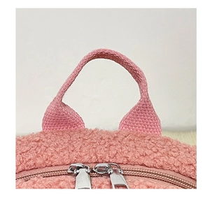Detail view of pink plush backpack with lamb wool fabric and metal zipper closure