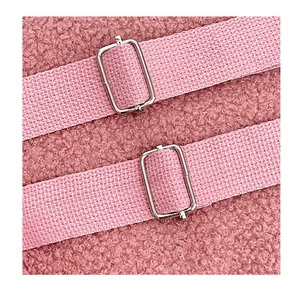 Close-up of pink faux fur fabric texture with adjustable metal buckle on straps