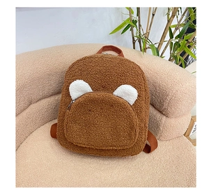 Detail of plush teddy fleece backpack with cute bear ears on soft beige background