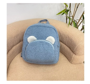Detail of blue plush backpack featuring cute white bear ears and lamb wool texture