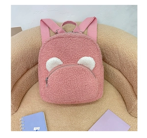 Close-up of pink plush teddy bear backpack with cute ears and fleece texture