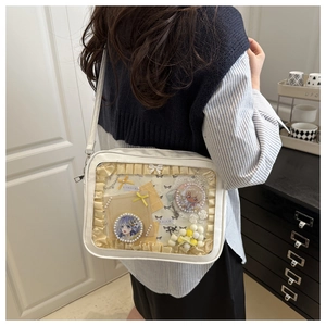 Detailansicht einer weißen Ita-Bag mit transparentem Fenster und Anime-Anstecknadeln
