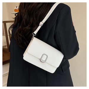 Close-up of white minimalist crossbody bag with silver oval metal buckle on a model