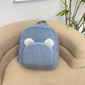 Cute light blue plush backpack with bear ears on a beige sofa, soft fleece school bag