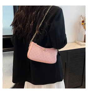 Detail of pink crescent bag featuring gold M logo and elegant metal chain strap