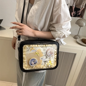Schwarze PU-Leder Ita-Bag mit transparentem Fenster und Anime-Badges auf einem Model