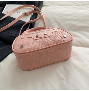 Dettaglio borsa rosa effetto coccodrillo con borchie argentate e trama in pelle