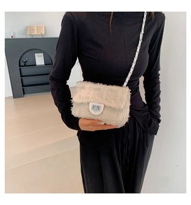 Detail of beige tweed crossbody bag with frayed edges and silver metallic twist lock