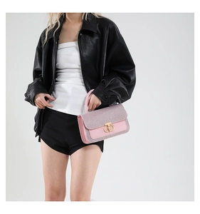 Detail of pink glitter and leather handbag featuring a signature gold metal lock