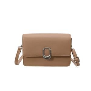 Minimalist light brown crossbody bag with silver oval buckle on a clean white backdrop