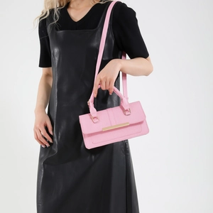 Chic pink small square handbag for women with gold metal bar accent and shoulder strap