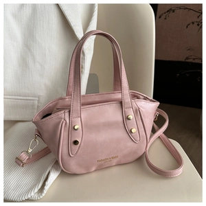 Detail view of the pale pink leather bucket bag with golden rivets and detachable strap
