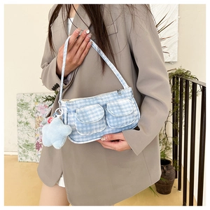 Close-up of blue and white plaid baguette bag with star charm and front pockets