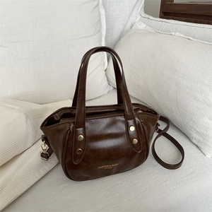 Deep brown vintage leather bucket bag with gold rivets and adjustable strap for women