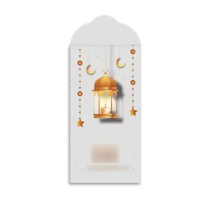 Détail d'une enveloppe cadeau blanche avec lanterne islamique dorée et croissant de lune