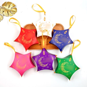 Star-shaped gift boxes with gold moon patterns and yellow satin ribbons for party favors