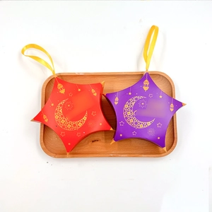 Detail of star-shaped paper gift boxes with gold moon and star patterns on a tray