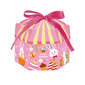 Détail d'une boîte cadeau hexagonale de Pâques rose avec motifs de lapins et ruban satin