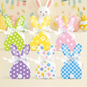 Scatole regalo con orecchie di coniglio pasquale, motivi colorati, nastri e code di peluche